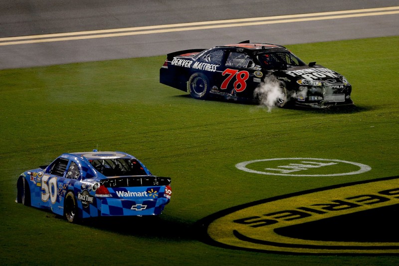 NASCAR, 2012 Coke Zero 400 Powered by Coca-Cola, Regan Smith and Bill Elliott racing on the grass.