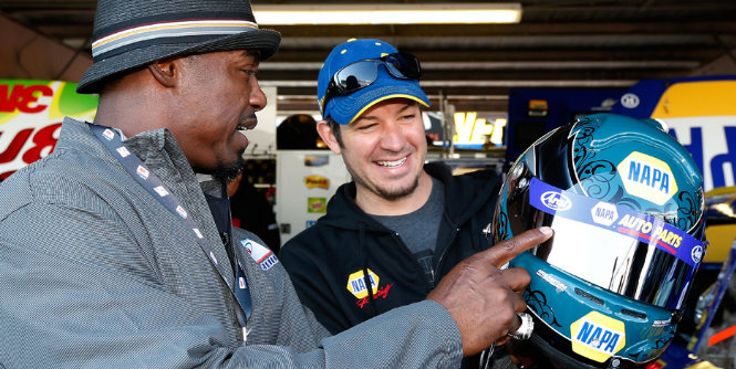 Martin Truex Jr. takes ex-NFL player Brian Dawkins on a tour of the garage prior to the race at Dover.