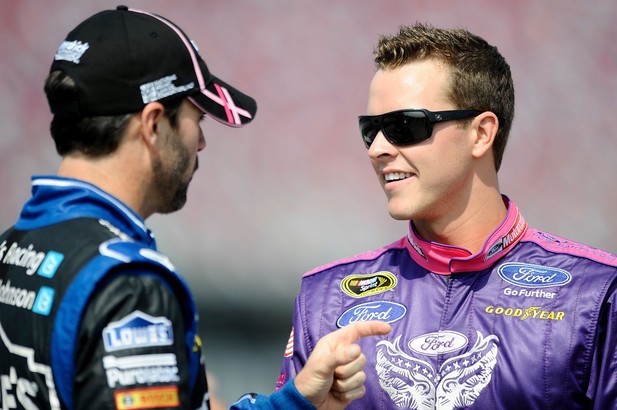 Jimmie Johnson, driver of the #48 Lowe's Chevrolet, talks with Trevor Bayne, driver of the #21 Motorcraft/Quick Lane/Warriors in Pink Ford, on the grid during qualifying at Talladega fall race 2012