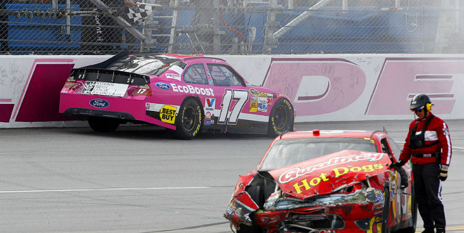 Kenseth survives final-lap crash to win Talladega. Matt Kenseth grabs the checkered flag after his chaotic Talladega win, passing by the crunched car of Aric Almirola.