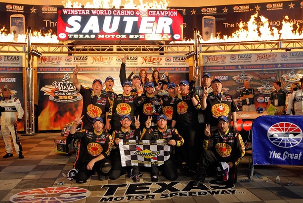FORT WORTH, TX - NOVEMBER 02: Johnny Sauter, driver of the #13 SealMaster/Curb Records Toyota, celebrates in Victory Lane with the trophy and his team after winning the NASCAR Camping World Truck Series WinStar World Casino 350k at Texas