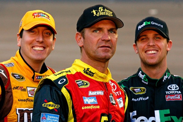 AVONDALE, AZ - NOVEMBER 09: Kyle Busch (L), driver of the #18 M&M's Toyota, Denny Hamlin (R), driver of the #11 FedEx Ground Toyota, and Clint Bowyer (C), driver of the #15 5-hour Energy Toyota, joke on the grid during qualifying for the NAS
