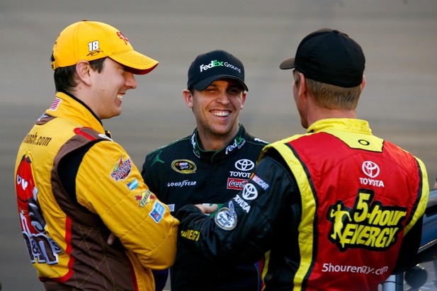 AVONDALE, AZ - NOVEMBER 09: (L-R) Kyle Busch, driver of the #18 M&M's Toyota, talks with Denny Hamlin, driver of the #11 FedEx Ground Toyota, and Clint Bowyer, driver of the #15 5-hour Energy Toyota, on the grid during qualifying for the NAS