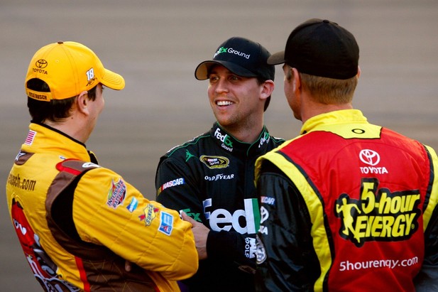 AVONDALE, AZ - NOVEMBER 09: (L-R) Kyle Busch, driver of the #18 M&M's Toyota, talks with Denny Hamlin, driver of the #11 FedEx Ground Toyota, and Clint Bowyer, driver of the #15 5-hour Energy Toyota, on the grid during qualifying for the NAS