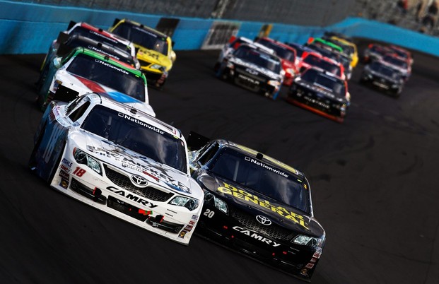 Joey Logano, driver of the #18 GameStop/Epic Mickey2 Toyota, races Brian Vickers, driver of the #20 Dollar General Toyota, during the NASCAR Nationwide Series Great Clips 200 at Phoenix