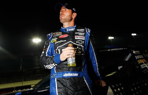 Jimmie Johnson, driver of the #48 Lowe's Chevrolet, stands next to his car on the grid after qualifying for the NASCAR Sprint Cup Series Ford EcoBoost 400 at Homestead