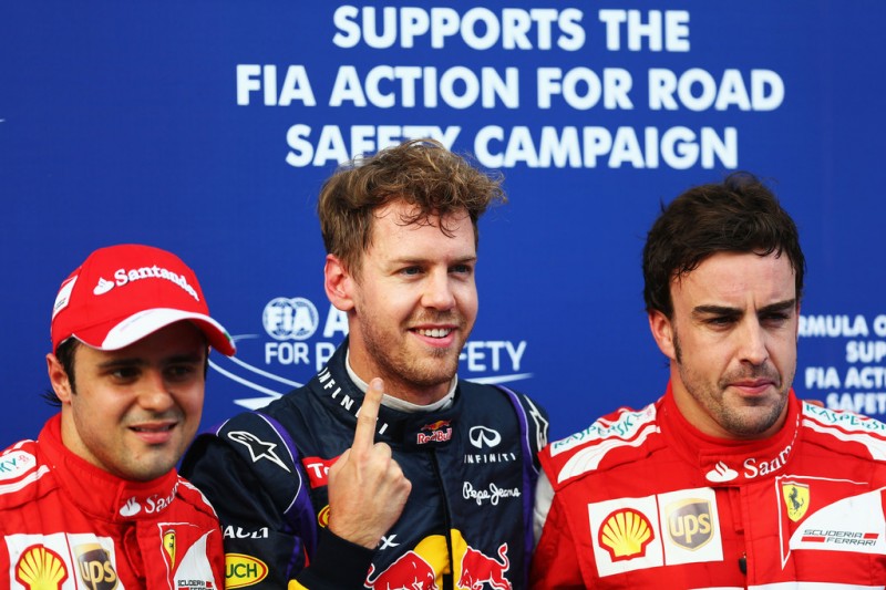 Pole sitter Sebastian Vettel (C) of Germany and Infiniti Red Bull Racing celebrates with second placed Felipe Massa (L) of Brazil and Ferrari and third placed Fernando Alonso (R) of Spain and Ferrari following qualifying for the Malaysian Formula One