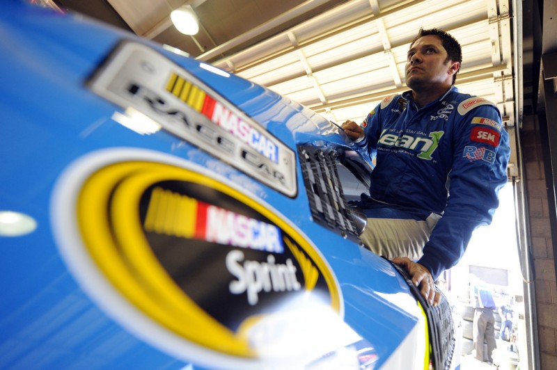 David Stremme, driver of the #30 Swan Energy/Lean1 Inception, climbs into his car during practice for the NASCAR Sprint Cup Series Auto Club 400 at Auto Club Speedway on March 22, 2013 in Fontana, California. 
