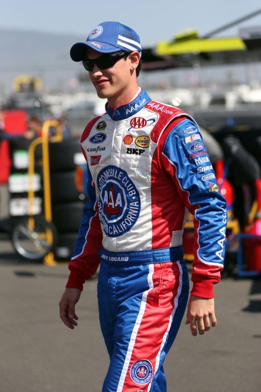 Joey Logano, driver of the #22 AAA Southern California Ford, stands in the garage during practice for the NASCAR Sprint Cup Series Auto Club 400 at Auto Club Speedway on March 22, 2013 in Fontana, California. 