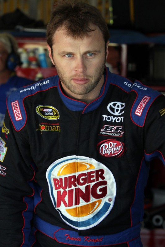 Travis Kvapil, driver of the #93 Burger King/Dr. Pepper Toyota, stands in the garage area during practice for the NASCAR Sprint Cup Series Auto Club 400 at Auto Club Speedway on March 22, 2013 in Fontana, California.