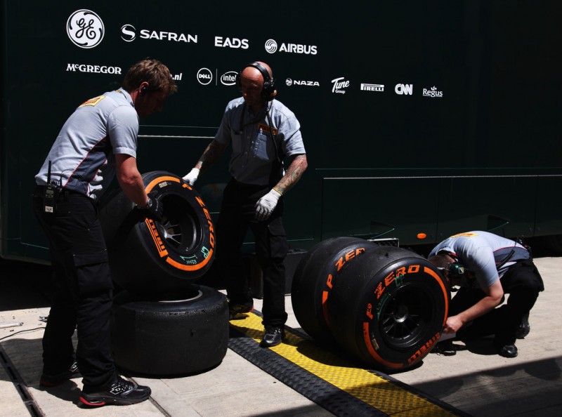 Pirelli engineers examine a set of their orange hard compound tyres in the paddock during the British Formula One Grand Prix at Silverstone Circuit on June 30, 2013 in Northampton, England. 
