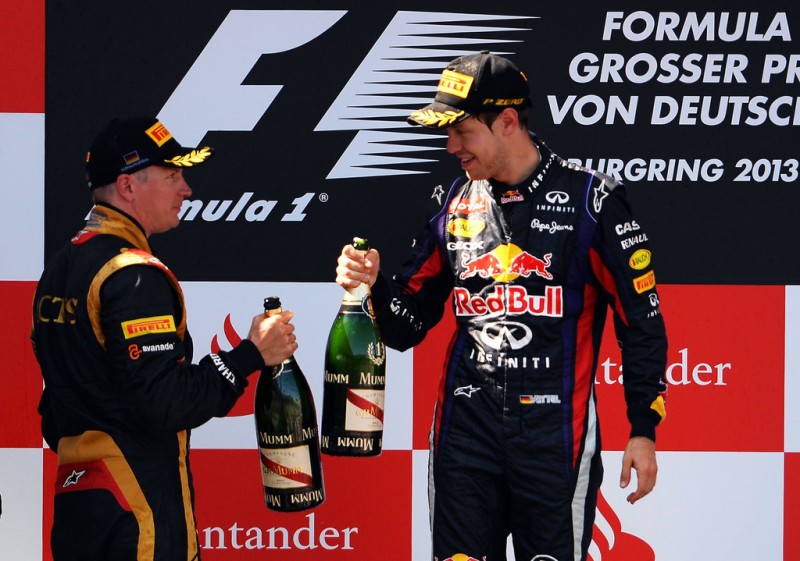 Race winner Sebastian Vettel (R) of Germany and Infiniti Red Bull Racing celebrates on the podium with second placed Kimi Raikkonen (L) of Finland and Lotus following the German Grand Prix at the Nuerburgring on July 7, 2013 in Nuerburg, Germany. 