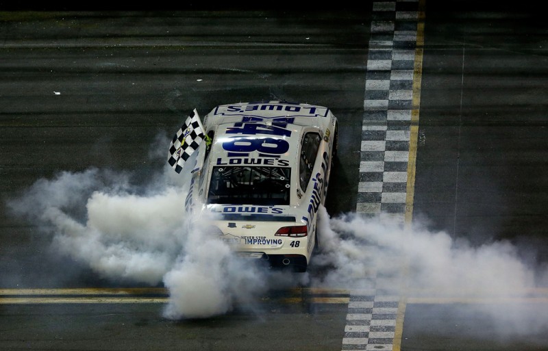 Jimmie Johnson, driver of the #48 Lowe's Dover White Chevrolet, celebrates with the checkered flag as he performs a burnout after winning the NASCAR Sprint Cup Series Coke Zero 400 at Daytona International Speedway on July 6, 2013 in Daytona Bea