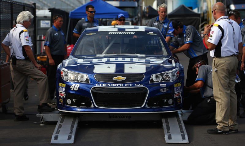 The crew of Jimmie Johnson look over the #48 Lowe's Chevrolet in the inspection area after failing an initial inspection before qualifying for the NASCAR Sprint Cup Series Camping World RV Sales 301 at New Hampshire Motor Speedway on July 12, 20