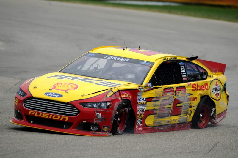 Joey Logano drives the wrecked #22 Shell-Pennzoil/AAA Ford after cutting a tire in the NASCAR Sprint Cup Series Camping World RV Sales 301 at New Hampshire Motor Speedway on July 14, 2013 in Loudon, New Hampshire. 