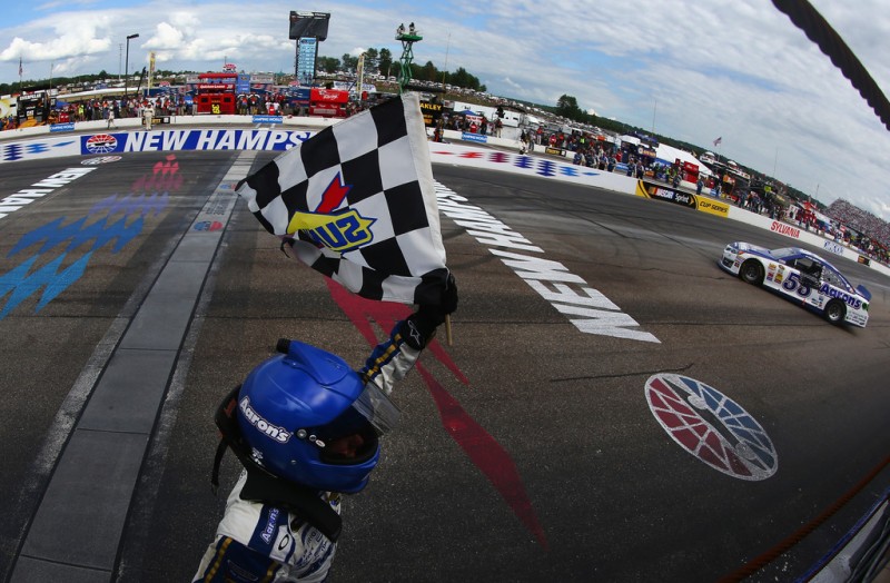 Brian Vickers, driver of the #55 Aaron's Dream Machine Toyota, celebrates with the checkered flag after winning the NASCAR Sprint Cup Series Camping World RV Sales 301 at New Hampshire Motor Speedway on July 14, 2013 in Loudon, New Hampshire. 