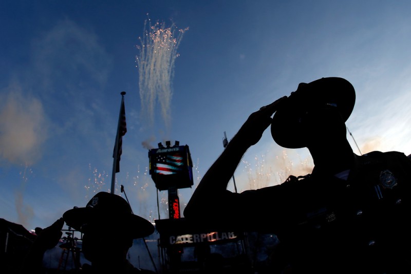 Law enforcement officers look on during the national anthem before the start of the NASCAR Sprint Cup Series Irwin Tools Night Race at Bristol Motor Speedway on August 23, 2014 in Bristol, Tennessee. 