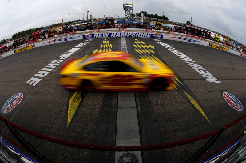 Joey Logano, driver of the #22 Shell-Pennzoil Ford, crosses the finish line to win the NASCAR Sprint Cup Series Sylvania 300 at New Hampshire Motor Speedway on September 21, 2014 in Loudon, New Hampshire. 