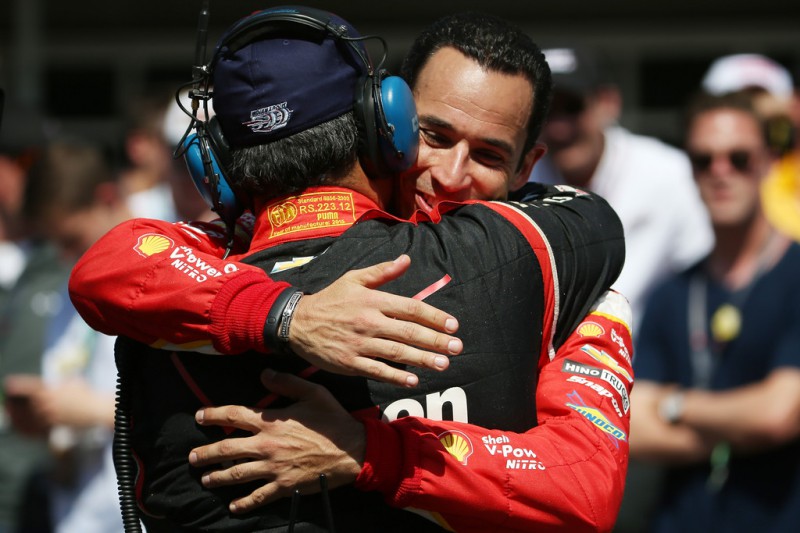 Juan Pablo Montoya of Colombia driver of the #2 Team Penske Chevrolet Dallara is congratulated after winning the 99th running of the Indianapolis 500 mile race by Helio Castroneves of Brazil driver of the #3 Team Penske Dallara Chevrolet at Indianapolis Motorspeedway on May 24, 2015 in Indianapolis, Indiana.