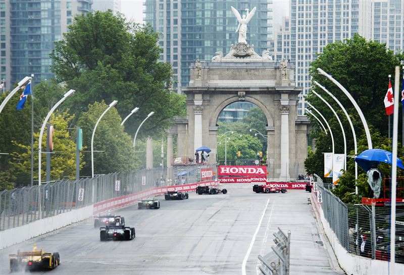 Indy cars race down past the start line towards the Princes' Gates during the Honda Toronto IndyCar race in Toronto on Sunday, June 14, 2015.