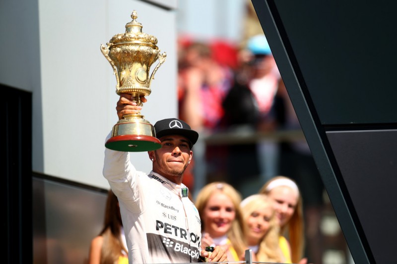 Lewis Hamilton of Great Britain and Mercedes GP celebrates on the podium after winning the Formula One Grand Prix of Great Britain at Silverstone Circuit on July 5, 2015 in Northampton, England. 