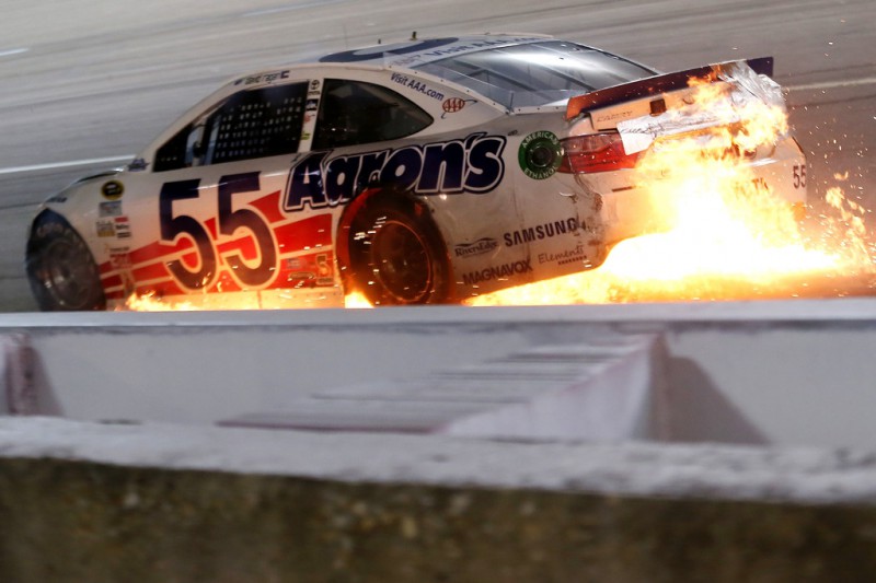 The #55 Ol' Aaron's Dream Machine Toyota, driven by David Ragan, catches fire after being involved in an on-track incident during the NASCAR Sprint Cup Series Bojangles' Southern 500 at Darlington Raceway on September 6, 2015 in Darlington, South Carolina. 