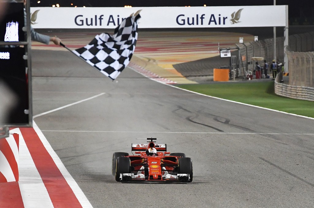 Ferrari's German driver Sebastian Vettel drives his car past the chequered flag to win the Bahrain Formula One Grand Prix at the Sakhir circuit in Manama on April 16, 2017. Ferrari's German driver Sebastian Vettel drives his car past the chequered flag to win the Bahrain Formula One Grand Prix at the Sakhir circuit in Manama on April 16, 2017.
