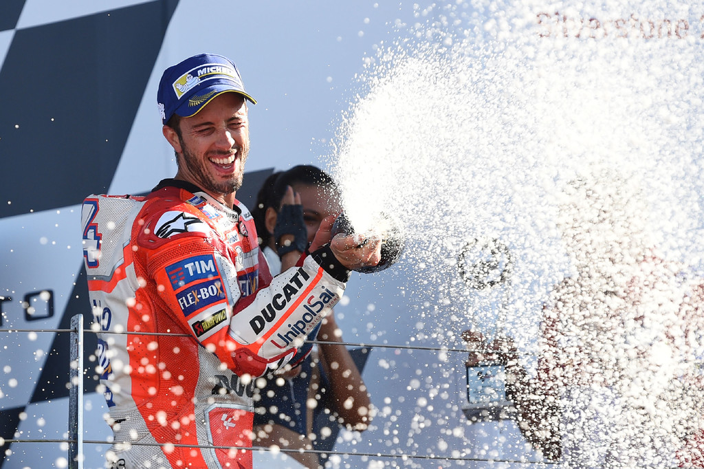 Ducati Team's Italian rider Andrea Dovizioso celebrates first place on the rostrum after the MotoGP race of the British Grand Prix at Silverstone circuit in Northamptonshire, southern England, on August 27, 2017. Ducati Team's Italian rider Andrea Dovizioso celebrates first place on the rostrum after the MotoGP race of the British Grand Prix at Silverstone circuit in Northamptonshire, southern England, on August 27, 2017.