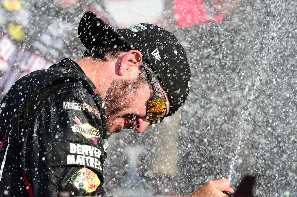 Martin Truex Jr., driver of the #78 Furniture Row/Denver Mattress Toyota, celebrates by spraying champagne in Victory Lane after winning the Monster Energy NASCAR Cup Series I Love NY 355 at The Glen at Watkins Glen International on August 6, 2017 in Watkins Glen, New York. Martin Truex Jr., driver of the #78 Furniture Row/Denver Mattress Toyota, celebrates by spraying champagne in Victory Lane after winning the Monster Energy NASCAR Cup Series I Love NY 355 at The Glen at Watkins Glen International on August 6, 2017 in Watkins Glen, New York.