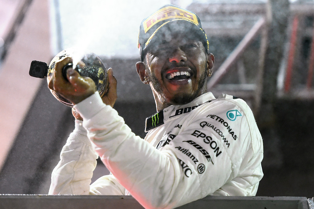 Mercedes' British driver Lewis Hamilton sprays champagne after winning the Formula One Singapore Grand Prix in Singapore on September 17, 2017. Mercedes' British driver Lewis Hamilton sprays champagne after winning the Formula One Singapore Grand Prix in Singapore on September 17, 2017.